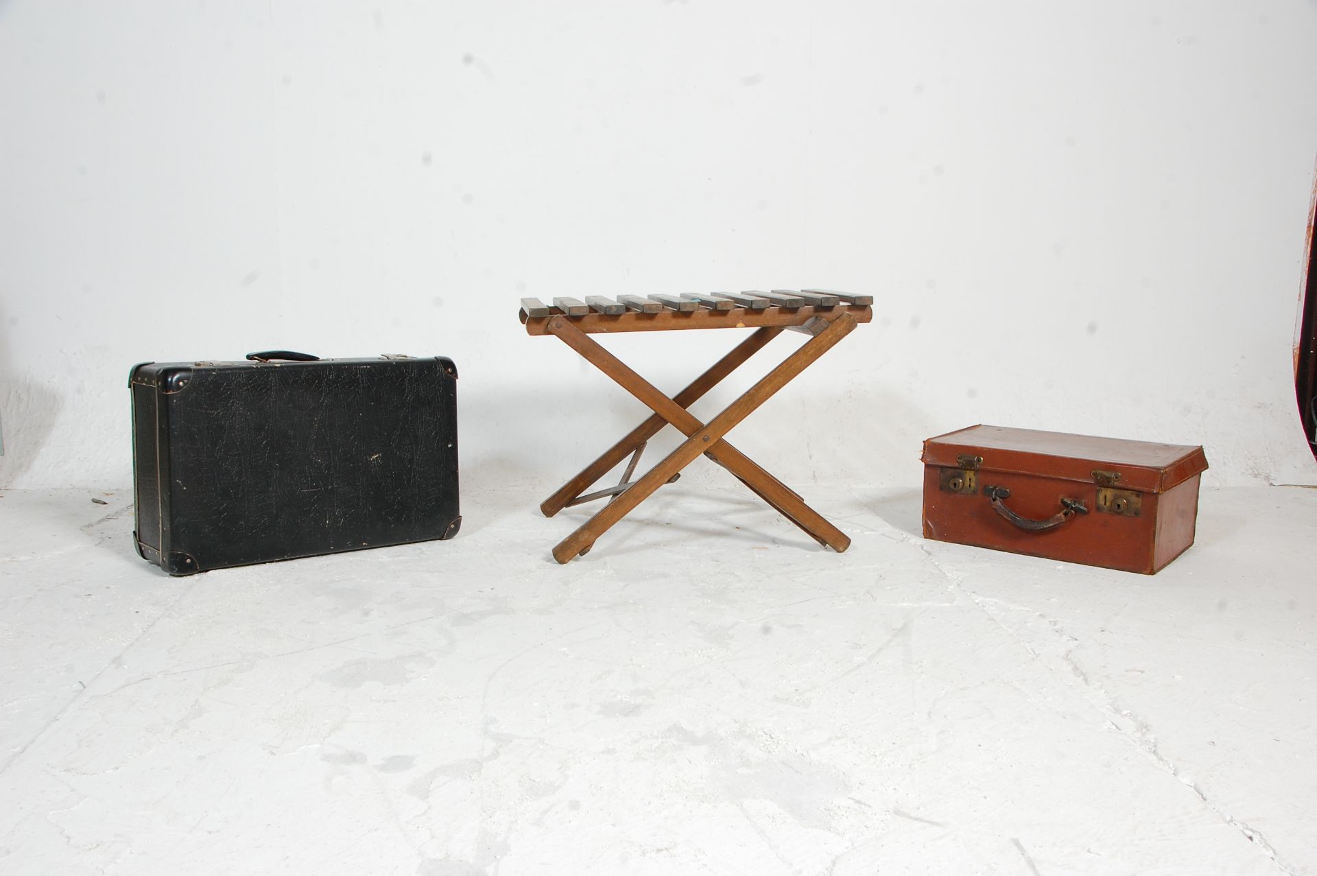 Two vintage leather suitcases mounted on a vintage metamorphic folding wooden slatted suitcase
