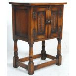 An early 20th Century Ipswich oak style cupboard of small proportions raised on block and turned