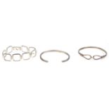 A group of three silver ladies bracelet bangles one having hinged panels and box clasp together with