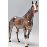 A good 20th century Beswick horse porcelain figurine of a race horse having a dark coat with brushed