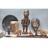 A mixed group of African tribal wooden wares to include multiple face masks, large wooden carved