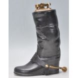 An antique 20th century brass table lighter in the form of a black leather riding boot complete with