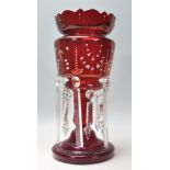 A 19th Century Victorian cranberry glass mantle piece lustre having a crenelated rim and columnal