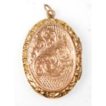 A Victorian 9ct gold back and front oval locket having engraved floral and scroll decoration and
