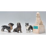 A collection of vintage dog figurines to an alabaster hound raised on a plinth base, a Beswick