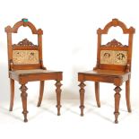 A pair of 19th Century Victorian antique oak hall chairs being raised on turned legs with panelled