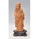 An early 20th Century Chinese carved boxwood figure of an elder shown carrying Buddha. Raised on a