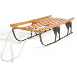 A vintage 20th Century wooden sledge / sleigh having a wooden slatted body with ebonised metal