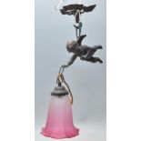 An antique cast metal ceiling pendant light in the form of a cherub having a ribbon design sconce,