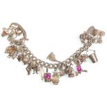 A good vintage silver charm bracelet adorned with many charms and having a heart padlock clasp.