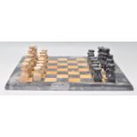 A 20th Century vintage marble and fossil stone chess board with carved and polished stone chess