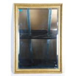 A 20th Century antique style wall mirror of rectangular form having bevelled glass with a gilt