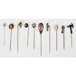 A collection of stick pins to include silver, gold, yellow and white metal examples. Decorated