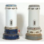 A pair of vintage 20th Century paraffin heaters of cylindrical form raised on rounded bases.