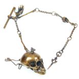 A brass albert watch chain with bone spacers, T bar and key, with an articulated skull. Measures