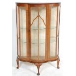 An early 20th Century 1930's Art Deco walnut demi lune display cabinet being raised on cabriole legs