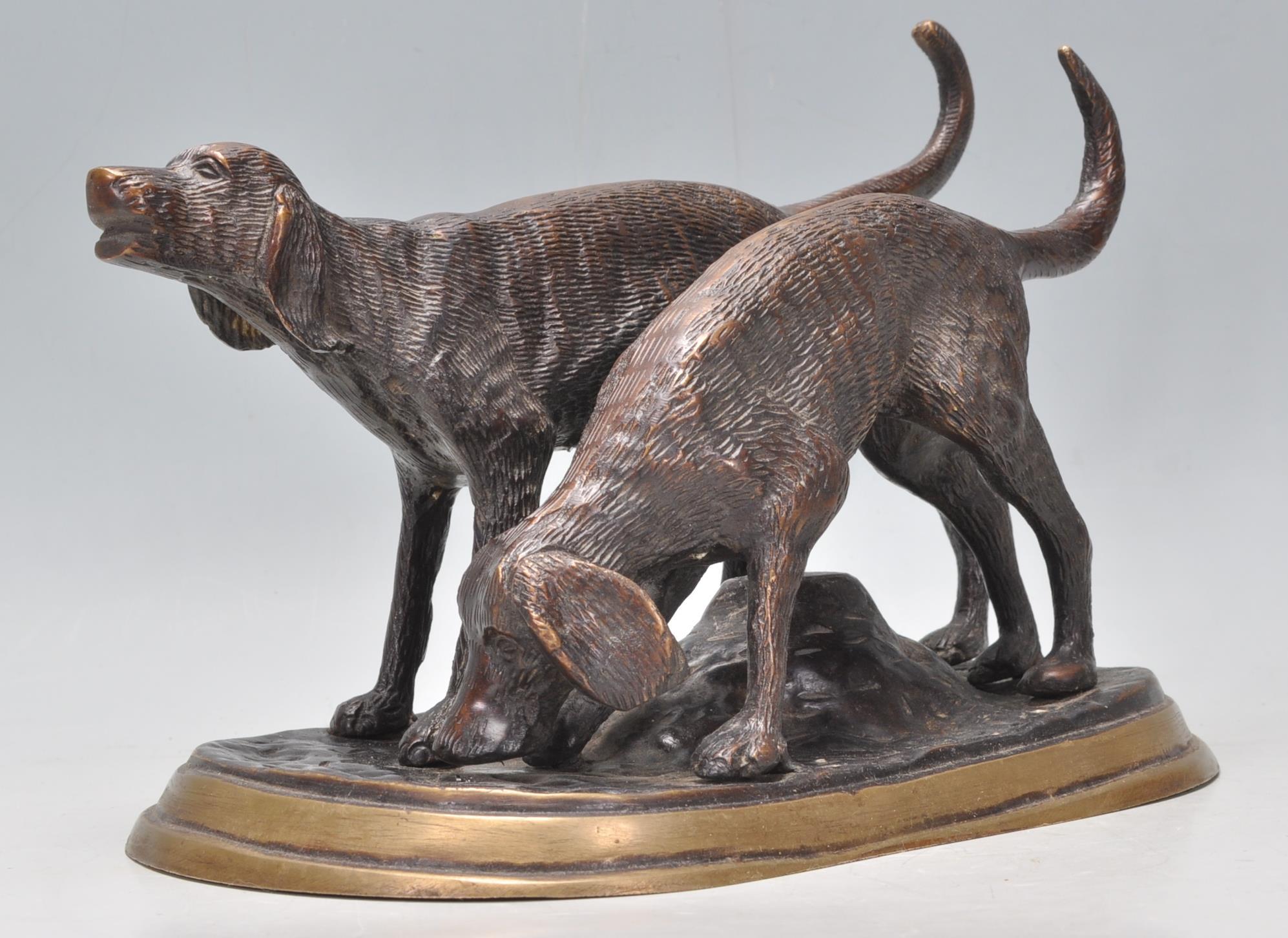 A vintage 20th Century bronze figure depicting a two hunting dogs. Raised on a rounded base.