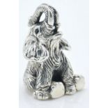 A stamped sterling silver figurine in the form of a seated elephant with engraved details and