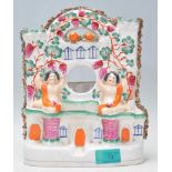 A 19th Century Victorian Staffordshire ceramic clock stand hand painted with two cherubs and florals