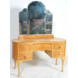 An early 20th Century Art Deco walnut dressing table of kidney shaped form having adjustable mirrors