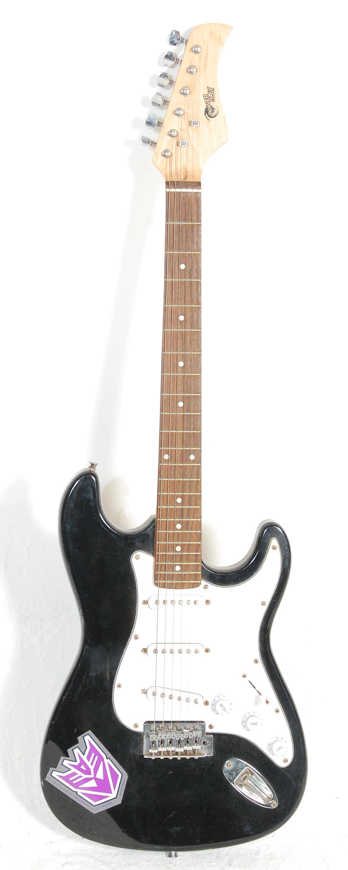 A six string electric guitar by Power Play having a black body with a white scratch guard, fretboard