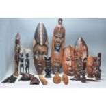 A collection of African and Asian tribal wooden wares to include figurative wall masks. fertility