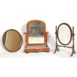 A group of three antique 19th Century mirrors to include a swing mirror of round shape raised on