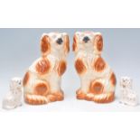A pair of large 19th century Staffordshire spaniels in the manner of Beswick together with another