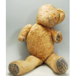 A vintage early to mid 20th Century childs teddy bear constructed from mohair with leather patches