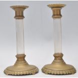 A pair of 19th Century antique brass candlestick having round bases with reeded rims, having faceted