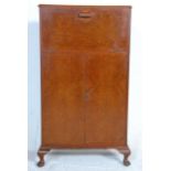 A 1940's / 1950's post war Art Deco style walnut cocktail / drinks cabinet having a full front and