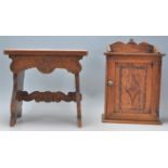 A good early 20th Century carved oak stool together with a single door oak hanging cupboard.