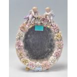 A 19th Century Victorian Meissen style barbola porcelain mirror having a floral encrusted border