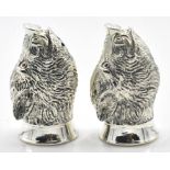 A pair of stamped 800 silver salt and pepper condiments in the form of boars heads set with red