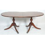 An antique mahogany folding breakfast table having two D end table tops raised on columnal