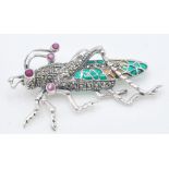 A stamped 925 silver bug brooch in the form of a locust having green plique a jour panels, set