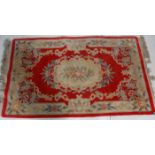 A vintage, believed early 20th Century Chinese floor rug having a red ground with floral works and