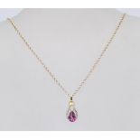 A lovely gold on silver mounted faceted cut pink stone droplet flanked by white accent stones. The