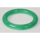 A Chinese green jade bangle of typical round form. Interior diameter 5.4cm. Weighs 76g.