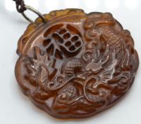 A Chinese yellow stone pendant carved into relief