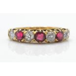 An 18ct gold garnet and diamond 7 stone band ring.