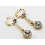 A pair of gold and diamond drop earrings. The earr