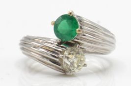 An emerald and diamond toi et moi ring. Estimated