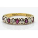 An 18ct gold ruby and diamond band ring. The ring