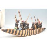 An African tribal carved wooden boat figurine complete with striped painted sides, complete with
