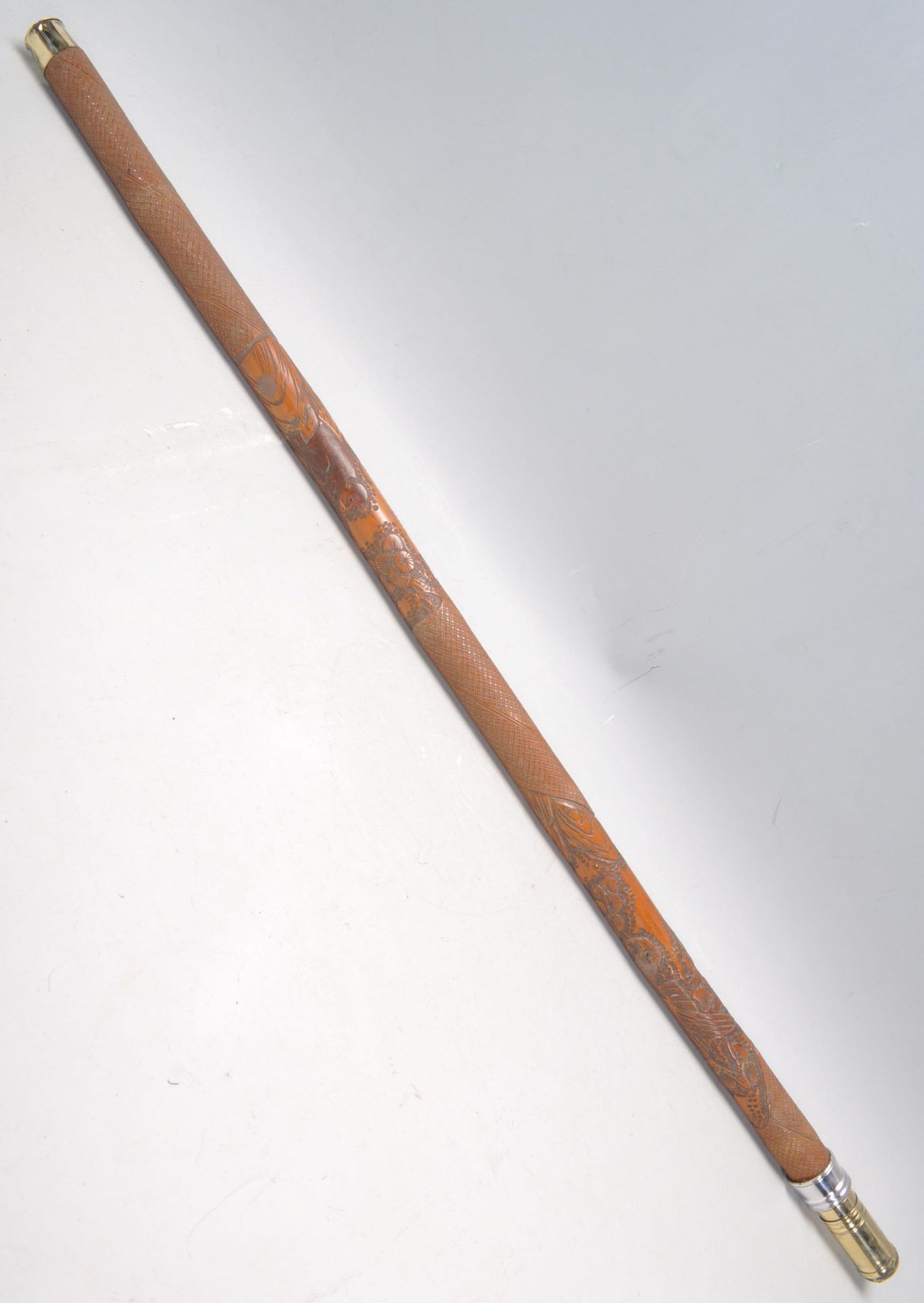 A heavily carved sword stick / walking stick decorated with a carved monkey with floral and