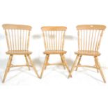 A set of three 20th Century Windsor style beech wood spindle back dining chairs having shaped