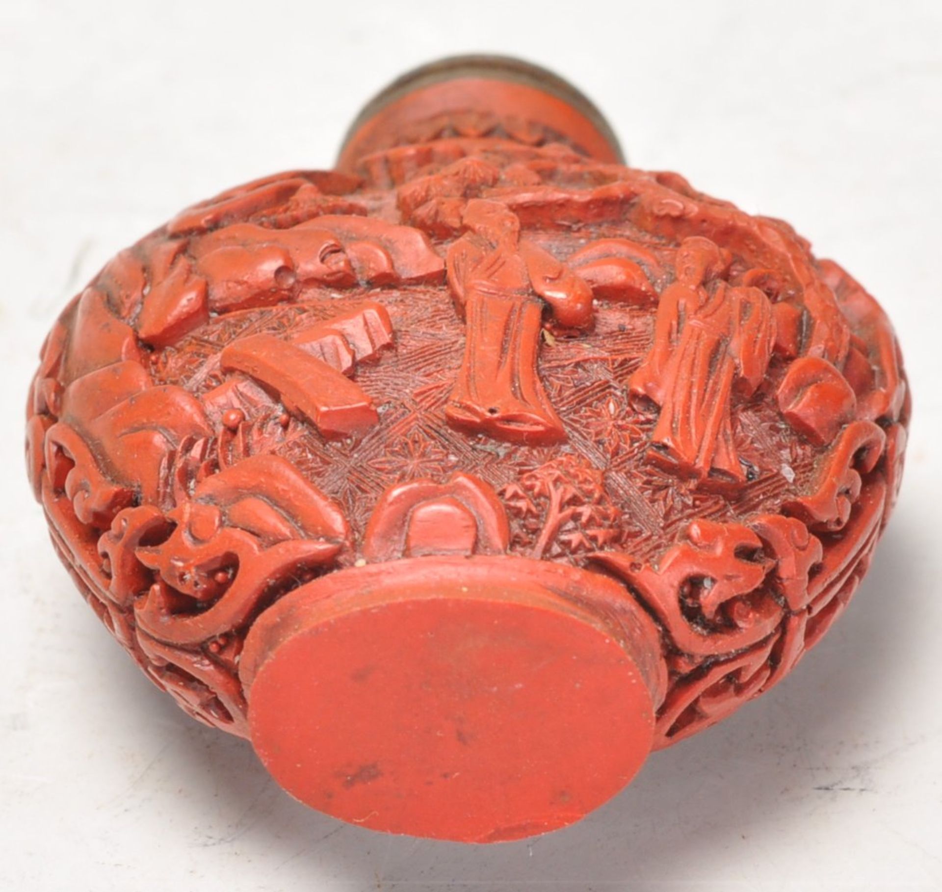 An Antique Chinese red cinnabar snuff bottle carved with landscape scenes and carved stopper atop. - Image 6 of 6