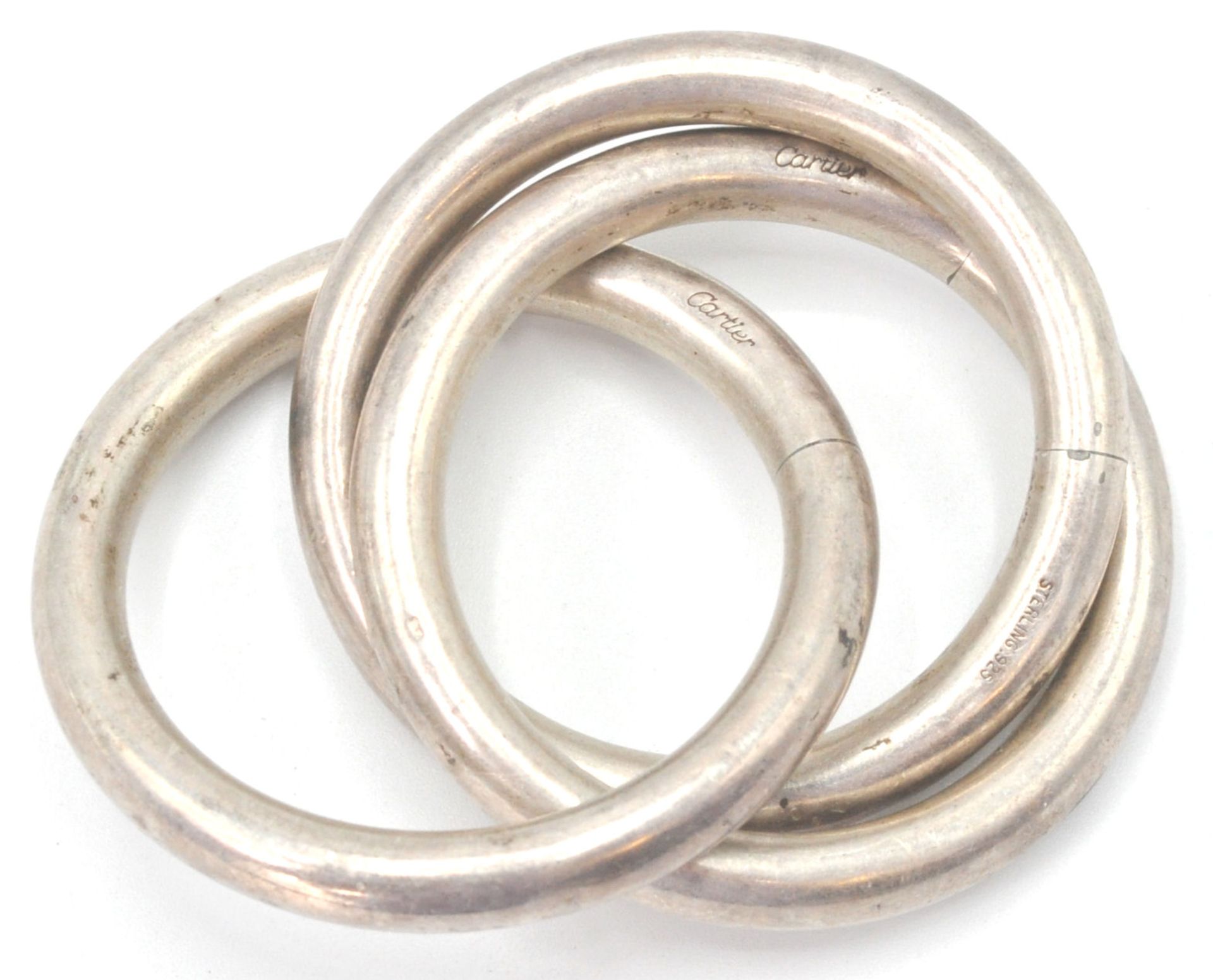 An early 20th century Cartier sterling silver puzzle rattler - teething ring with 3 conjoined