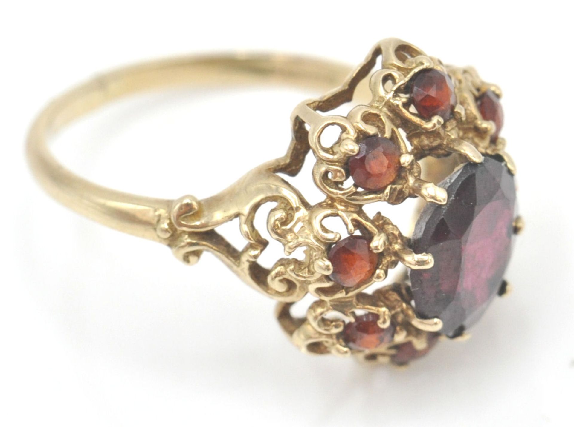 A 9ct gold hallmarked cluster ring. The ring set with oval facet cut garnet within a pierced setting - Bild 3 aus 8